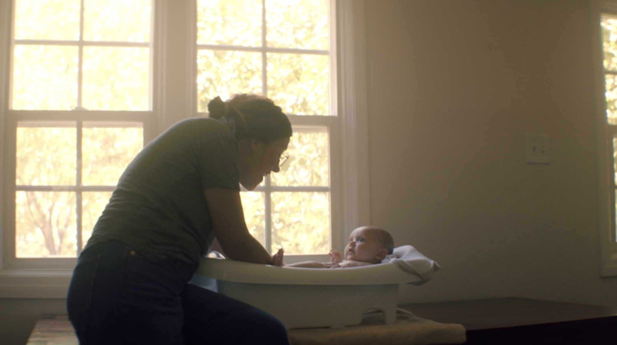 Water is life campaign film poster: a parent bathing a baby